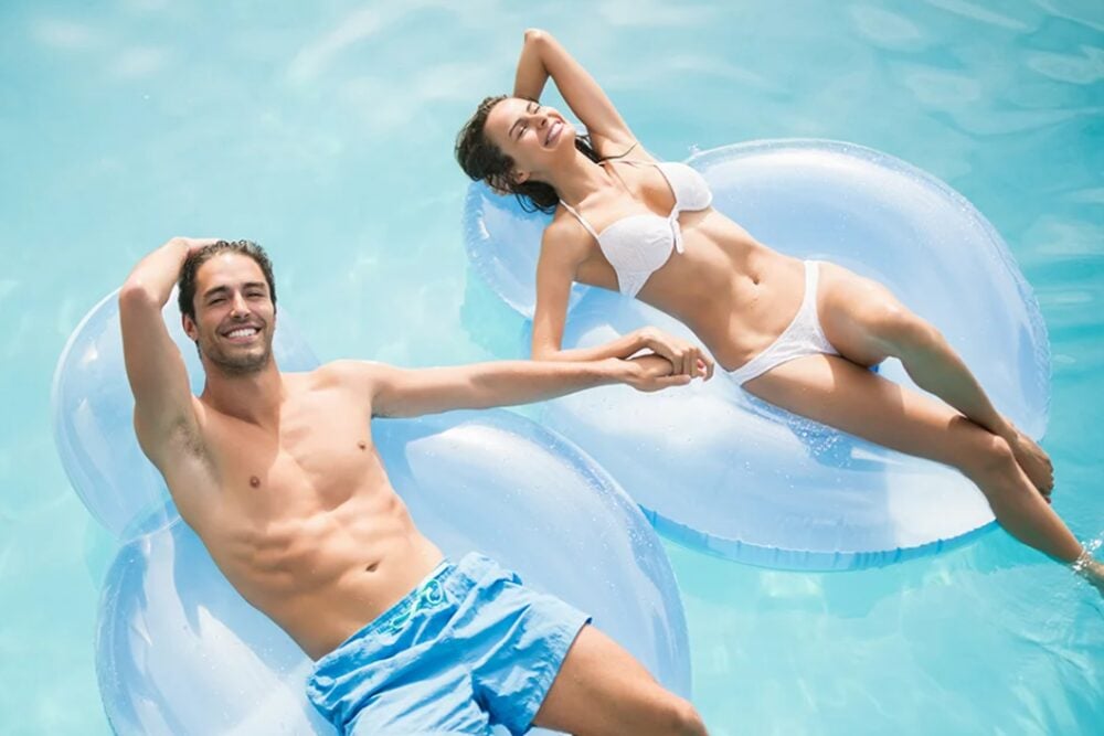 Couple relaxing by a pool after liposuction in San Antonio